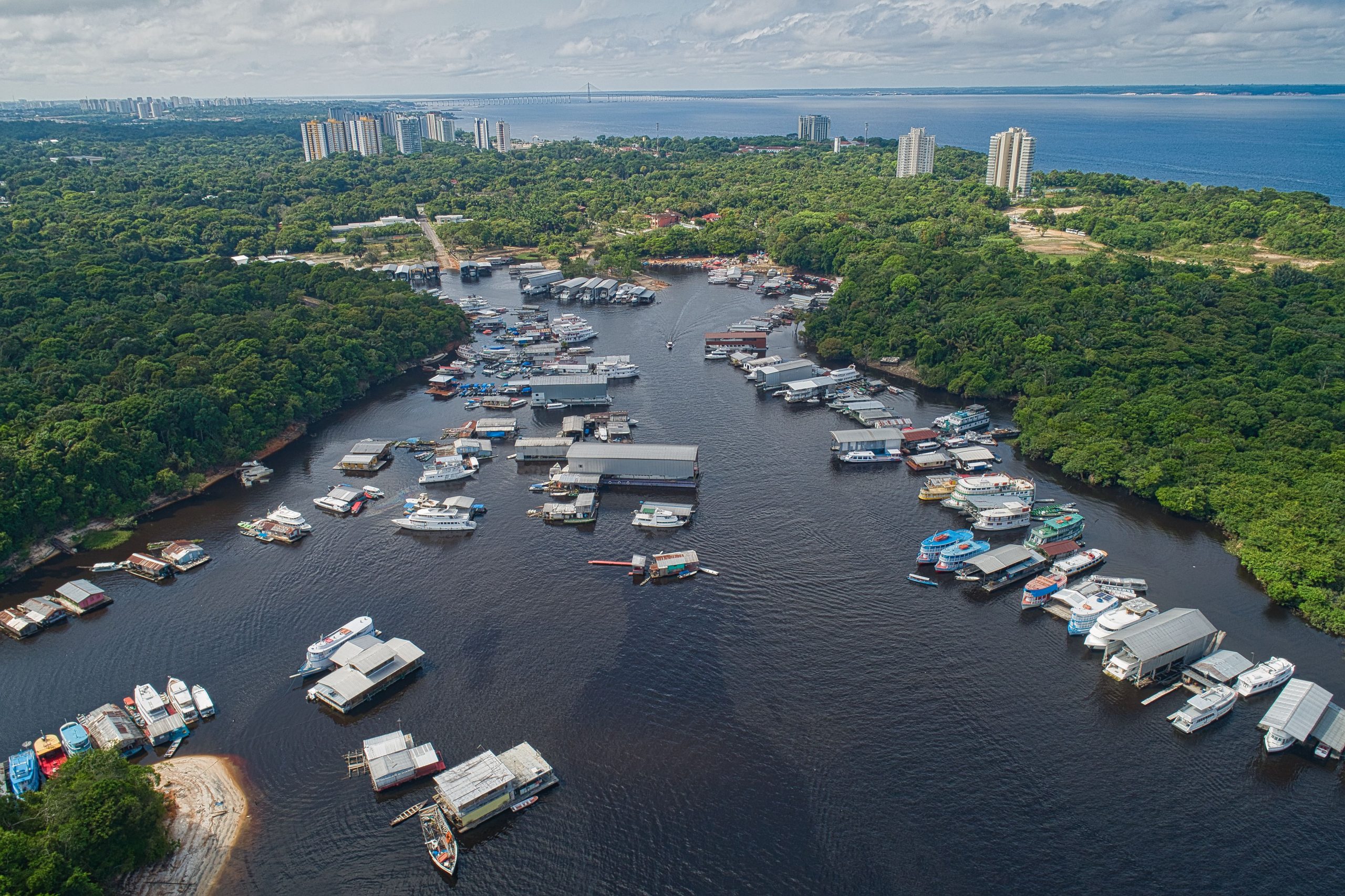 Barcos de madeira atracados junto ao porto flutuante de Manaus, inaugurado em 1907, em frente à densa floresta amazônica, na capital do Estado do Amazonas